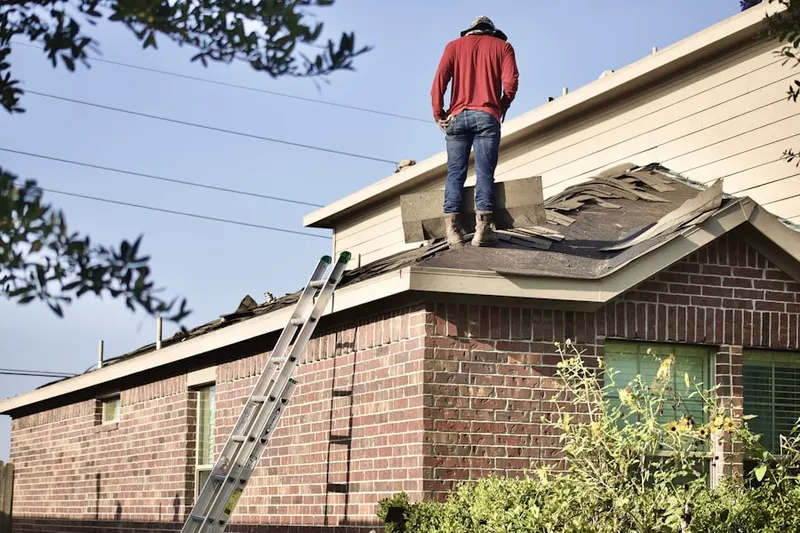 Professional roofer working on a residential roof in Penn Weldy
